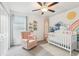 Bedroom features natural light, a ceiling fan, and decorative touches creating a sweet, welcoming space for a little one at 6398 Bar S Bar Trl, Zephyrhills, FL 33541