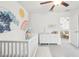 Bedroom features playful wall art, white furniture, and an open layout that connects to a nearby living space at 6398 Bar S Bar Trl, Zephyrhills, FL 33541