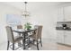 Cozy dining room featuring a contemporary chandelier, a table with seating for four and a large window at 6398 Bar S Bar Trl, Zephyrhills, FL 33541
