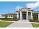 Striking building entrance featuring grand columns, symmetrical landscaping, and an elegant facade at 6398 Bar S Bar Trl, Zephyrhills, FL 33541