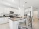 Modern kitchen featuring a granite-topped island, stainless steel appliances, white cabinetry and lighting at 6398 Bar S Bar Trl, Zephyrhills, FL 33541