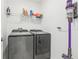 Efficient laundry room with modern washer and dryer, storage shelf and a sleek mounted vacuum at 6398 Bar S Bar Trl, Zephyrhills, FL 33541