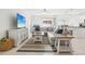 Bright living room featuring a large couch, tile floors, and an entertainment center with television at 6398 Bar S Bar Trl, Zephyrhills, FL 33541