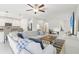 Bright living room with white walls, tile floors, modern ceiling fan and a large couch at 6398 Bar S Bar Trl, Zephyrhills, FL 33541