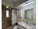 Bathroom features shower with curtain, toilet, modern light and sink with granite countertop at 6533 Brentwood Dr, Zephyrhills, FL 33542
