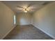 Spacious bedroom with neutral carpet, ceiling fan, and well-lit by window at 6533 Brentwood Dr, Zephyrhills, FL 33542