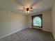 Neutral bedroom featuring ceiling fan, carpeted floor and a rounded window with natural light at 6533 Brentwood Dr, Zephyrhills, FL 33542