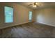 Spacious bedroom with neutral carpet, ceiling fan, and well-lit by windows at 6533 Brentwood Dr, Zephyrhills, FL 33542