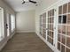 Well lit bonus room with wood floors, white trim, ceiling fan, and glass doors at 6533 Brentwood Dr, Zephyrhills, FL 33542