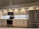 Updated kitchen features stainless steel appliances, granite countertops, and neutral backsplash at 6533 Brentwood Dr, Zephyrhills, FL 33542
