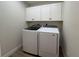 Laundry room with front load washer and dryer with upper storage cabinets at 6533 Brentwood Dr, Zephyrhills, FL 33542