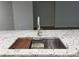Close up of a granite counter with a stainless sink, cutting board and drain at 6533 Brentwood Dr, Zephyrhills, FL 33542