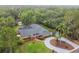 Beautiful aerial view of house with lush landscaping, circular driveway, and pond at 6703 Towhe Dr, Seffner, FL 33584
