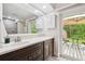 Bathroom with dark wood cabinets and a door to the backyard deck and outdoor space, blending indoor and outdoor living at 6703 Towhe Dr, Seffner, FL 33584
