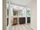 Hallway bathroom featuring modern fixtures, a large mirror, and wood-look flooring at 6703 Towhe Dr, Seffner, FL 33584