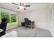 Bedroom with a ceiling fan, large window, and a comfortable workspace at 6703 Towhe Dr, Seffner, FL 33584