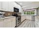 Bright kitchen with stainless steel appliances, granite countertops, and a view to the outside at 6703 Towhe Dr, Seffner, FL 33584