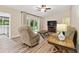 Comfortable living room includes wood-look floors and a sliding glass door for backyard access at 6703 Towhe Dr, Seffner, FL 33584