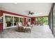 Enclosed patio with a ceiling fan, skylight, and wicker furniture overlooking the lush backyard at 6703 Towhe Dr, Seffner, FL 33584