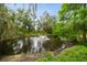 Picturesque pond featuring a fountain, framed by mature trees and Spanish moss at 6703 Towhe Dr, Seffner, FL 33584