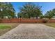 A backyard view with brick wall, green grass and stone patio at 6801 Bishops Pointe Way, Riverview, FL 33578