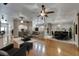 Open-concept living room featuring wood floors, ceiling fans, and views into the dining room and entryway at 6801 Bishops Pointe Way, Riverview, FL 33578