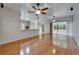 Spacious living room with hardwood flooring, ceiling fans, and an eat-in kitchen at 6801 Bishops Pointe Way, Riverview, FL 33578
