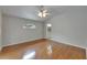 This main bedroom features wood floors, a ceiling fan, and a view into the main bathroom at 6801 Bishops Pointe Way, Riverview, FL 33578