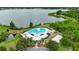 Stunning aerial view of a community pool near a serene lake with a water fountain at 6801 Bishops Pointe Way, Riverview, FL 33578