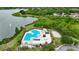 Community pool nestled by a tranquil lake, surrounded by lush greenery and a walking path at 6801 Bishops Pointe Way, Riverview, FL 33578