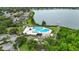 Aerial view of a beautiful community pool and lake, surrounded by lush greenery at 6801 Bishops Pointe Way, Riverview, FL 33578