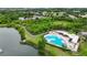 Community pool, path, and scenic lake view amidst lush vegetation from above at 6801 Bishops Pointe Way, Riverview, FL 33578
