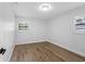 Empty bedroom features hardwood floors and two windows at 8307 Boxwood Dr, Tampa, FL 33615