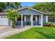 Charming home with a brick facade, white columns, and lush landscaping at 8307 Boxwood Dr, Tampa, FL 33615