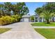 Home's exterior with lush green lawn, grey brick, and convenient driveway at 8307 Boxwood Dr, Tampa, FL 33615