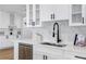 Close up on kitchen featuring white cabinets, dark hardware, stainless steel appliances, and stone backsplash at 8307 Boxwood Dr, Tampa, FL 33615