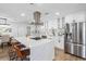 Bright kitchen boasts stainless steel appliances, island with cooktop, and sleek white cabinetry at 8307 Boxwood Dr, Tampa, FL 33615