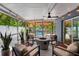 Enjoy this screened-in patio with modern seating, a fire pit, and partial view of the spa at 8307 Boxwood Dr, Tampa, FL 33615