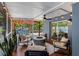 Inviting screened patio features cozy seating around a modern fire pit and view of the backyard at 8307 Boxwood Dr, Tampa, FL 33615