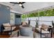 Relaxing screened porch features comfortable seating, a modern fire pit, and a ceiling fan for year-round enjoyment at 8307 Boxwood Dr, Tampa, FL 33615