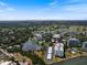 Aerial view of condo with community pool, manicured lawns, covered parking, and water view in Sarasota, Florida at 100 Oakmont Ln # 305, Belleair, FL 33756