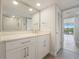 Bathroom featuring a vanity with quartz countertop, a large mirror, and a view to the lanai at 100 Oakmont Ln # 305, Belleair, FL 33756
