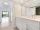Bright bathroom features white cabinetry, marble countertop, and a large mirror at 100 Oakmont Ln # 305, Belleair, FL 33756