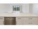 Kitchen counter with drawers and stainless steel dishwasher, opening into living space with a water view at 100 Oakmont Ln # 305, Belleair, FL 33756