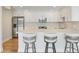 Modern kitchen featuring white cabinets, stainless steel appliances, a mosaic backsplash, and a breakfast bar at 100 Oakmont Ln # 305, Belleair, FL 33756