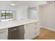 Modern kitchen featuring a quartz countertop island, stainless steel dishwasher, and views of the screened-in lanai at 100 Oakmont Ln # 305, Belleair, FL 33756