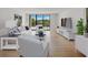 Bright, furnished living room with wood floors, comfy seating, and water views at 100 Oakmont Ln # 305, Belleair, FL 33756