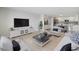 Bright living room with wood floors, comfortable seating, and an open floor plan to the updated kitchen at 100 Oakmont Ln # 305, Belleair, FL 33756