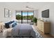 Bedroom with a beautiful lanai view, ceiling fan, and wooden dresser at 100 Oakmont Ln # 305, Belleair, FL 33756