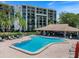 Inviting pool area with lounge chairs, lush landscaping, and a cabana offers a perfect spot for relaxation at 100 Oakmont Ln # 305, Belleair, FL 33756